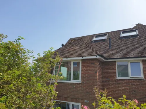 Wide view of Klober Uni Plain tile vent in red granular